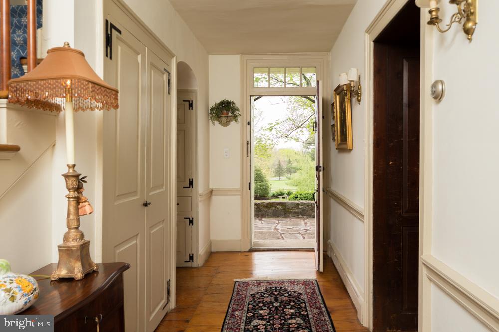 5736 Stoney Hill Road New Hope, PA 18938 - Photo 13 of 22 a view of a hallway with wooden floor and a livingroom with furniture