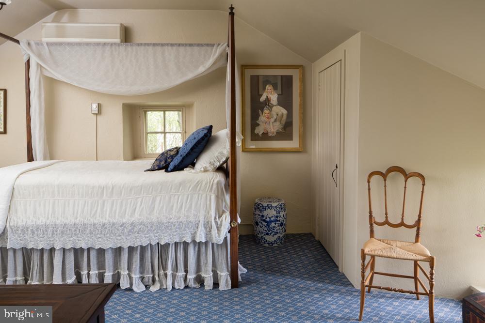 5736 Stoney Hill Road New Hope, PA 18938 - Photo 16 of 22 a bedroom with a bed and a chandelier