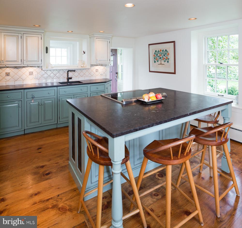 5736 Stoney Hill Road New Hope, PA 18938 - Photo 6 of 22 a kitchen with stainless steel appliances granite countertop a stove top oven a sink a dining table and chairs with wooden floor