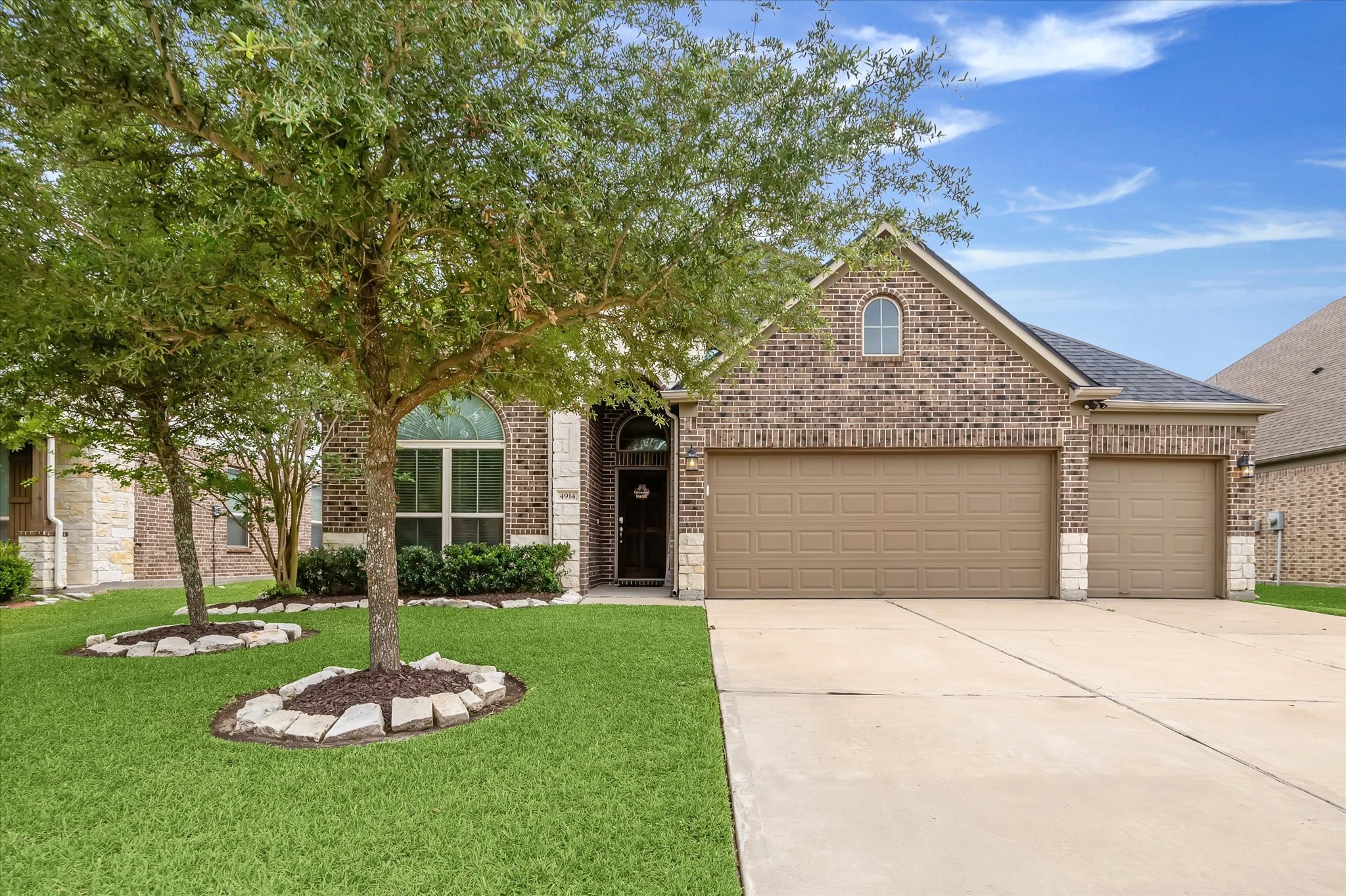 4914 Mountain Maple Trail Rosenberg, TX 77471 - Photo 3 of 24 Spacious three-car garage offering ample room for vehicles, storage, and all your outdoor essentials.