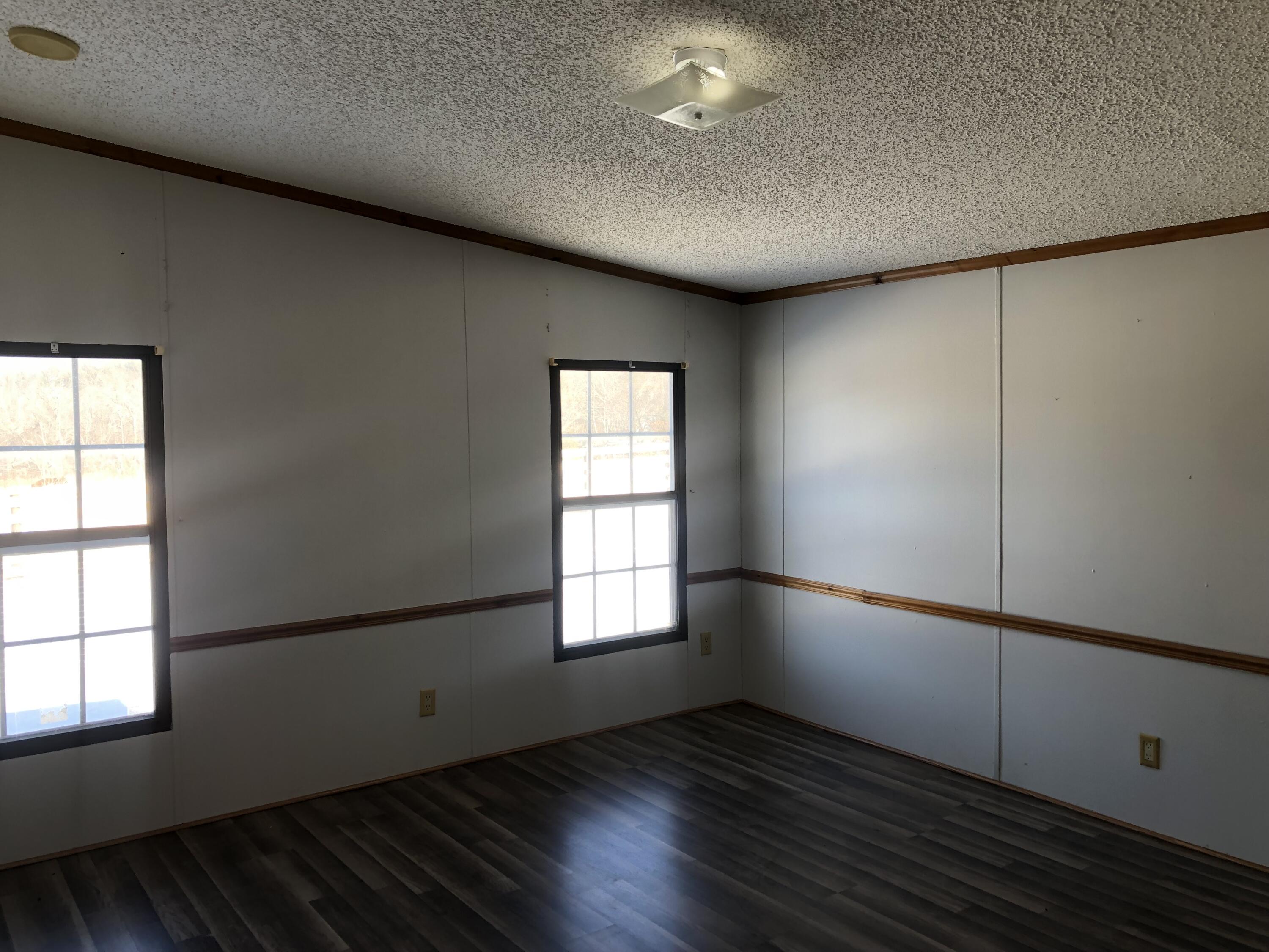 9210 Potts Creek Road Covington, VA 24426 - Photo 20 of 32 an empty room with wooden floor and windows