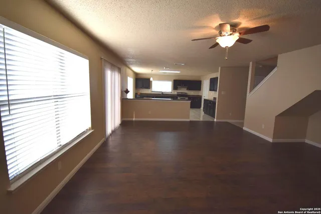 a view of a livingroom with a ceiling fan and window