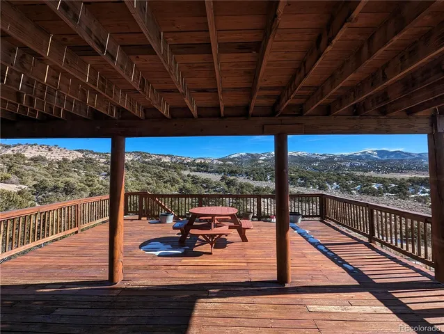a view of a balcony with chairs and wooden floor