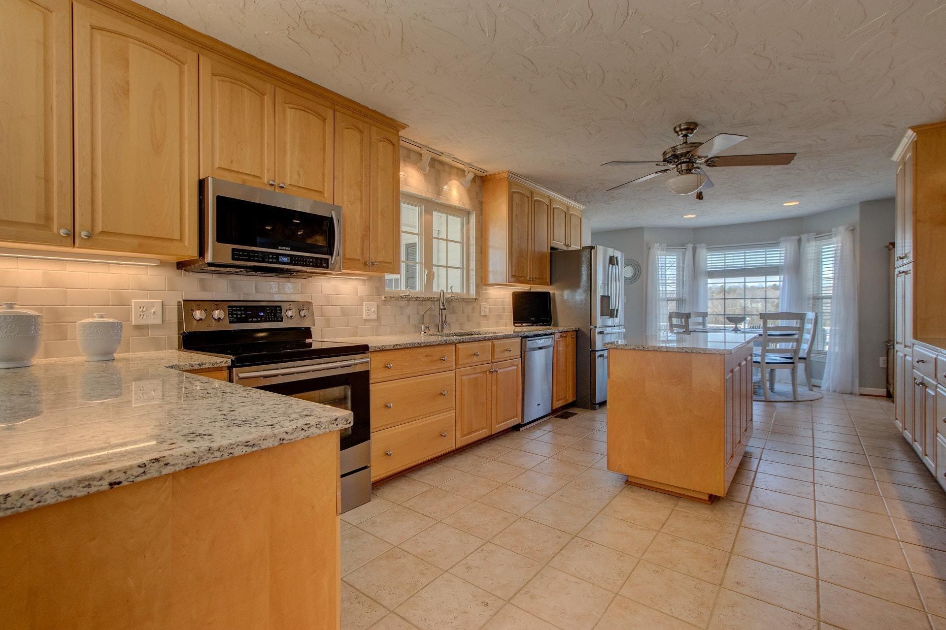 600 Dugwell Road Boones Mill, VA 24065 - Photo 5 of 78 a kitchen with stainless steel appliances granite countertop a refrigerator a stove top oven a sink dishwasher and white cabinets with wooden floor