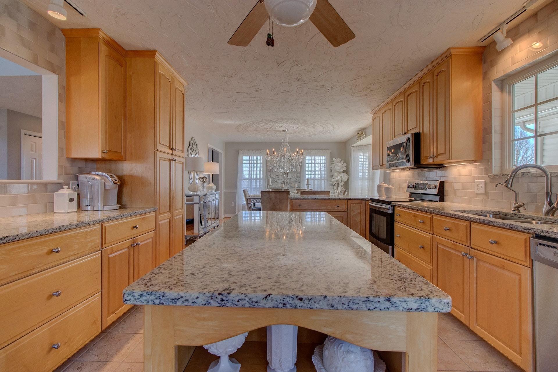 600 Dugwell Road Boones Mill, VA 24065 - Photo 39 of 78 a kitchen with kitchen island granite countertop wooden cabinets a sink a stove and a refrigerator