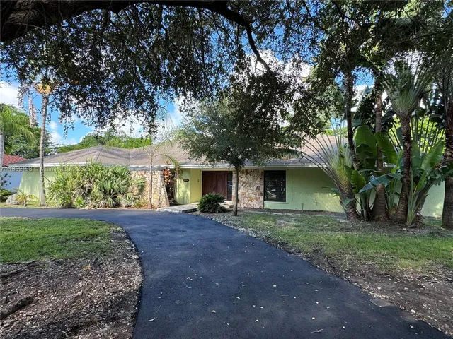 a front view of a house with a garden and yard