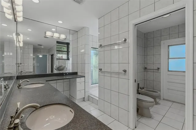 a white toilet sitting next to a bathroom sink