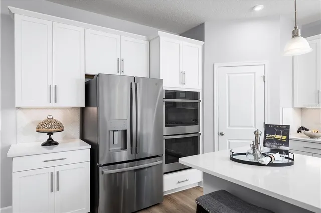 a kitchen with refrigerator and cabinets