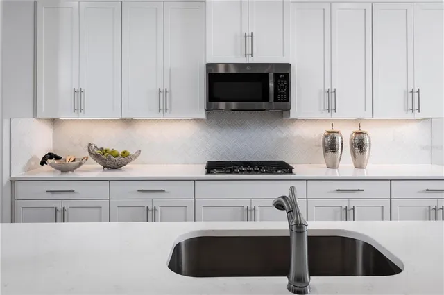 a kitchen with stainless steel appliances granite countertop a sink a stove and a microwave