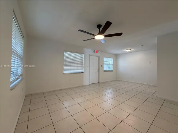 an empty room with windows and ceiling fan