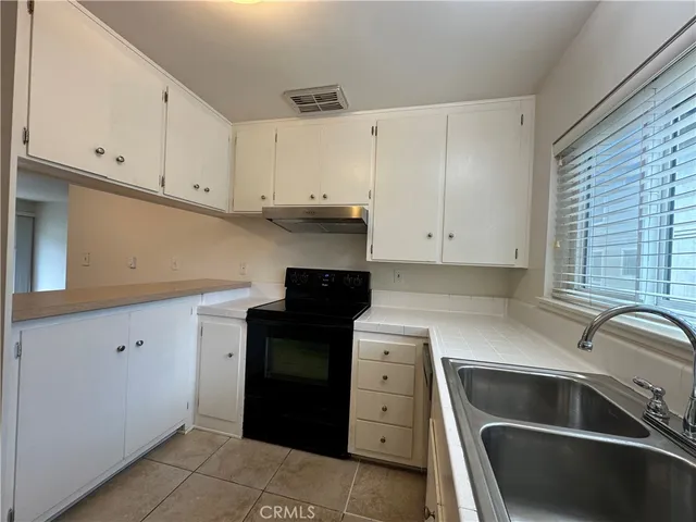 a kitchen with granite countertop a sink and a stove top oven