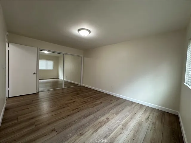 an empty room with wooden floor and bathroom