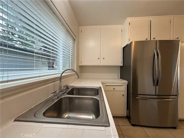 a kitchen with a refrigerator sink and cabinets