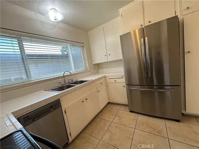 a kitchen with stainless steel appliances a refrigerator sink and cabinets