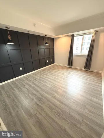 a view of a big room with wooden floor and windows
