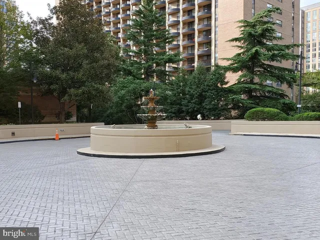 a view of fountain with tree in front of it