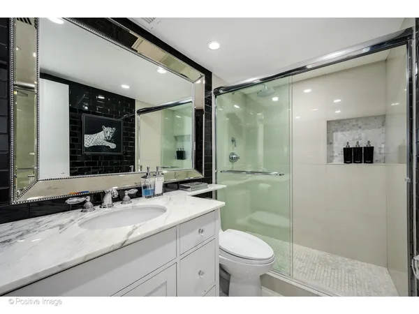 a bathroom with a granite countertop sink mirror and toilet
