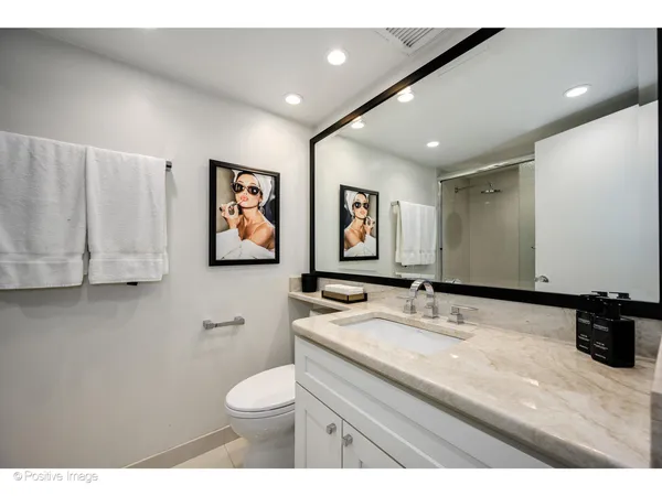 a bathroom with a granite countertop sink mirror and toilet