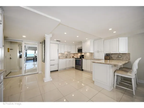 a kitchen with white cabinets and white appliances