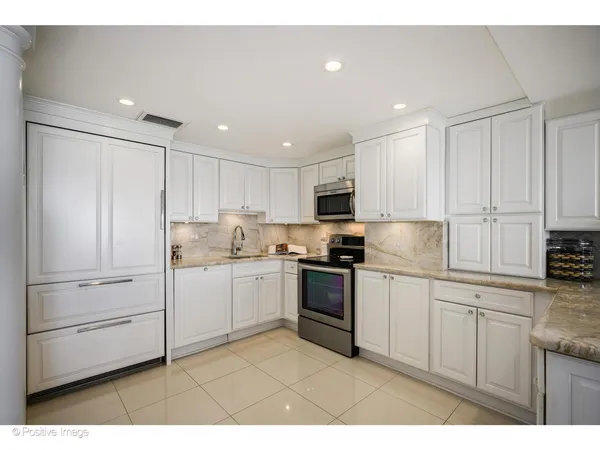 a kitchen with white cabinets and white appliances