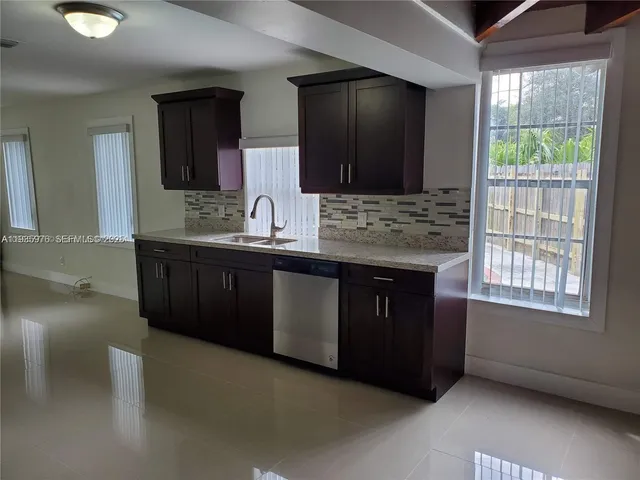 a kitchen with a sink and a mirror