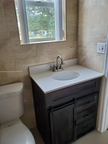 a bathroom with a sink a toilet and a window