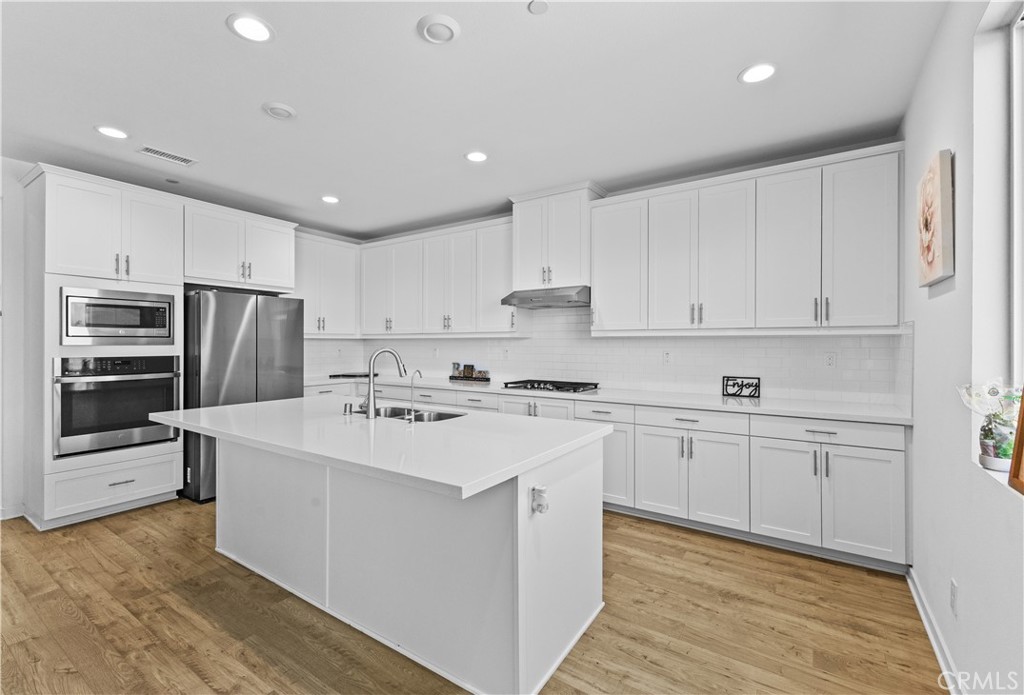 36780 Arietta Way Beaumont, CA 92223 - Photo 11 of 44 a kitchen with kitchen island a sink and white stainless steel appliances