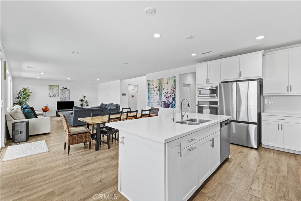 36780 Arietta Way Beaumont, CA 92223 - Photo 13 of 44 a kitchen with white cabinets and stainless steel appliances
