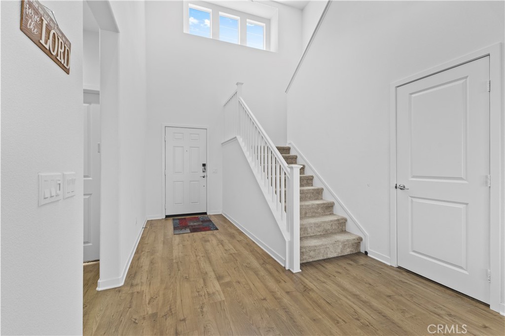 36780 Arietta Way Beaumont, CA 92223 - Photo 17 of 44 a view of a hallway with wooden floor and staircase