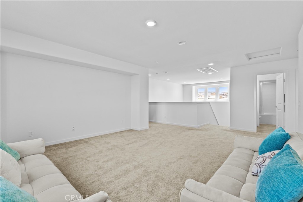 36780 Arietta Way Beaumont, CA 92223 - Photo 20 of 44 a living room with a couch and a kitchen view