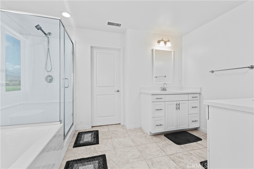 36780 Arietta Way Beaumont, CA 92223 - Photo 24 of 44 a spacious bathroom with a shower sink and a mirror