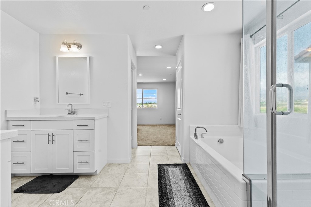 36780 Arietta Way Beaumont, CA 92223 - Photo 27 of 44 a spacious bathroom with a double vanity sink a mirror and a bathtub