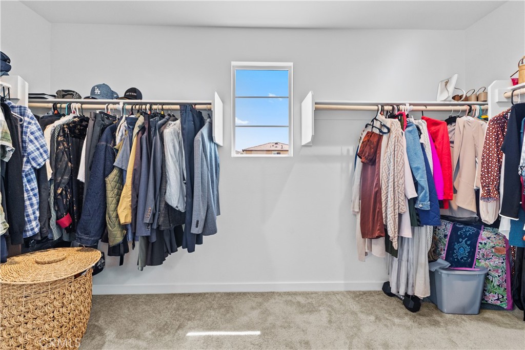 36780 Arietta Way Beaumont, CA 92223 - Photo 28 of 44 a view of walk in closet with clothes