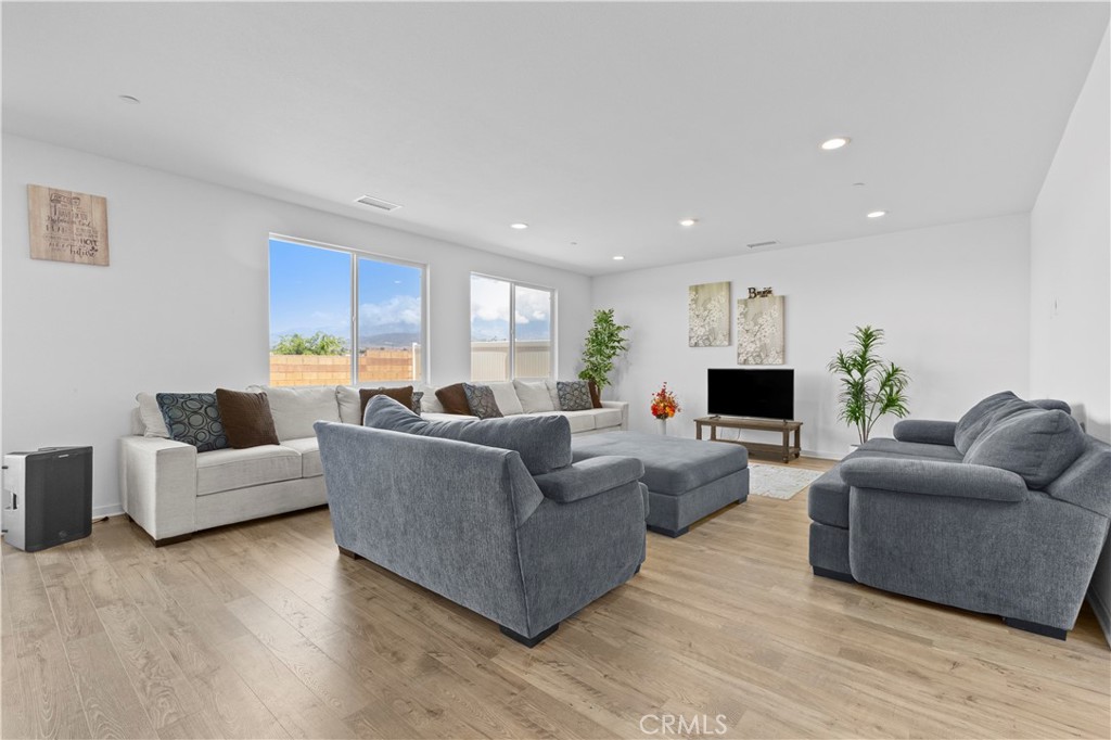 36780 Arietta Way Beaumont, CA 92223 - Photo 5 of 44 a living room with furniture a wooden floor and a fireplace