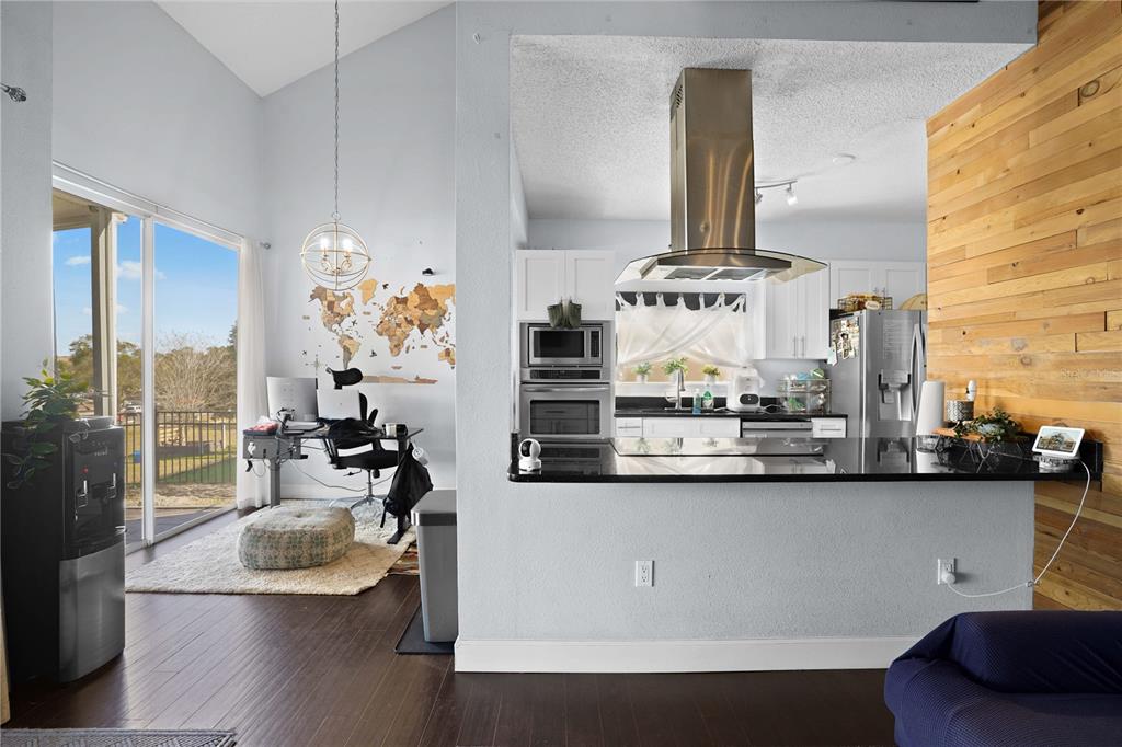 2619 Rangeley Court Orlando, FL 32835 - Photo 16 of 59 a kitchen with stainless steel appliances kitchen island granite countertop a stove and white cabinets with wooden floor