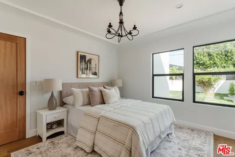 a bedroom with a large bed and a chandelier