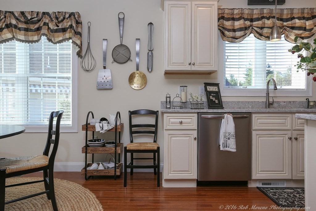 3 Dunrobin Circle, Unit 3 Methuen, MA 01844 - Photo 12 of 28 a kitchen with stainless steel appliances granite countertop a table chairs in it and wooden floors