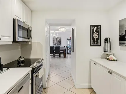 a kitchen with a sink and a stove top oven with wooden floor