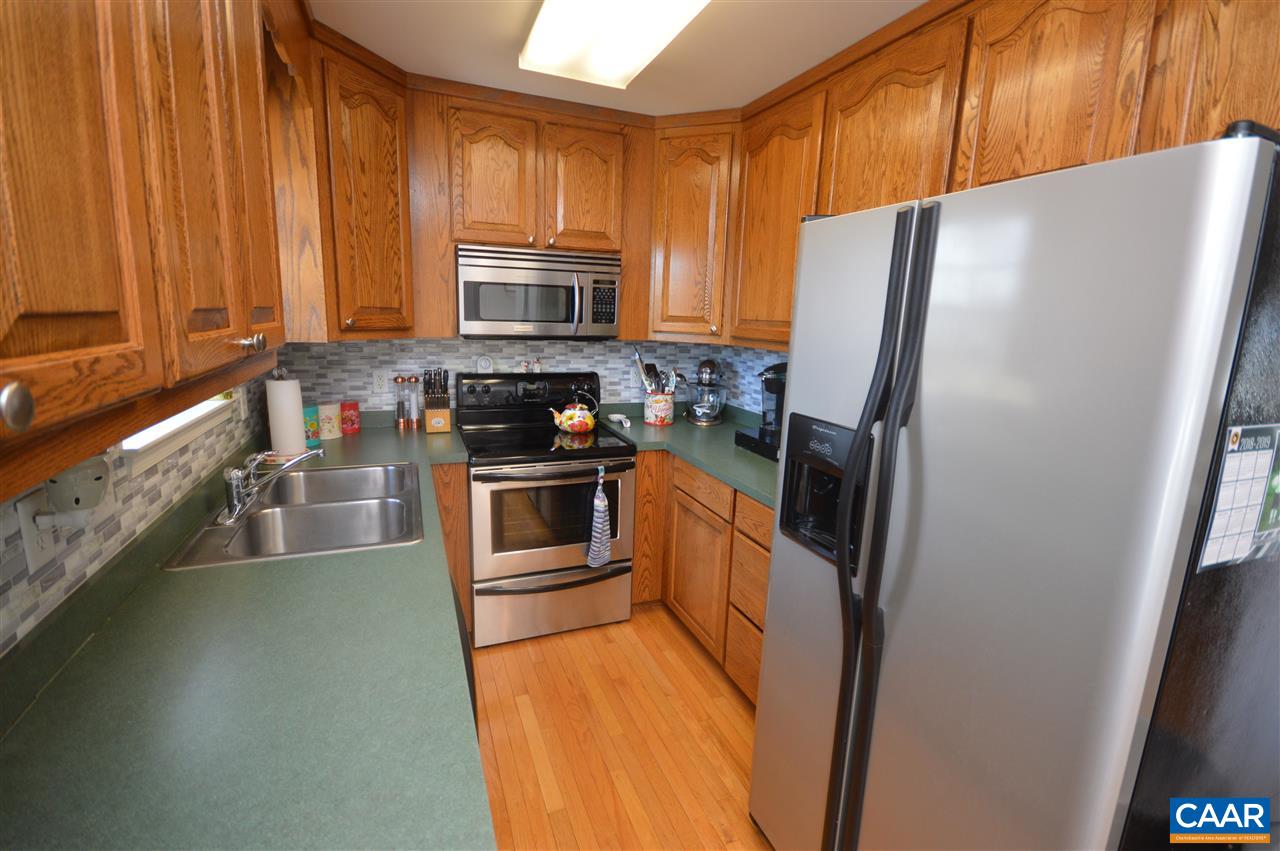 162 Stephens Loop Ruckersville, VA 22968 - Photo 4 of 29 a kitchen with granite countertop a refrigerator a sink a stove and white cabinets
