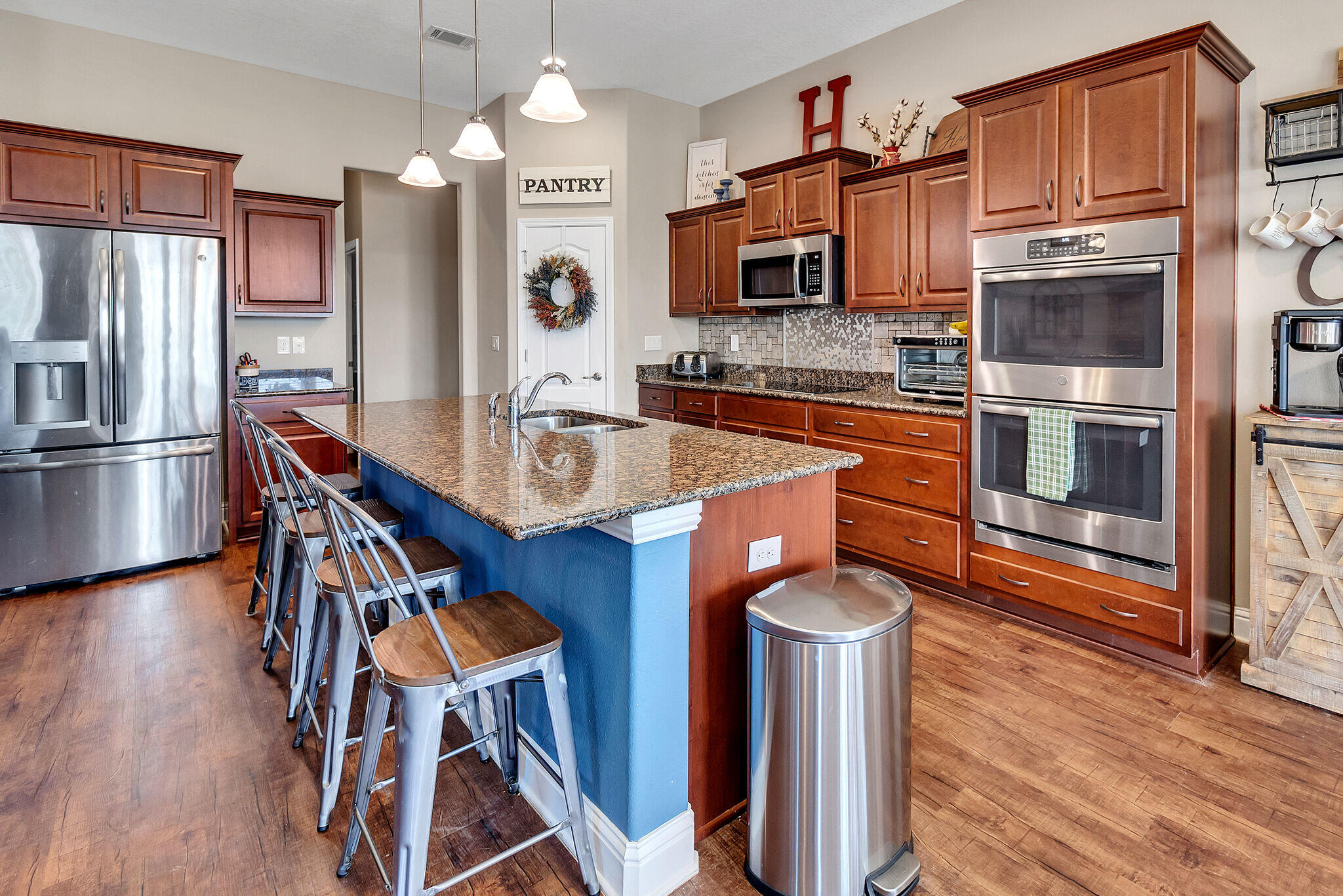 3044 Crown Creek Circle Crestview, FL 32539 - Photo 14 of 41 a kitchen with stainless steel appliances wooden floor and a refrigerator