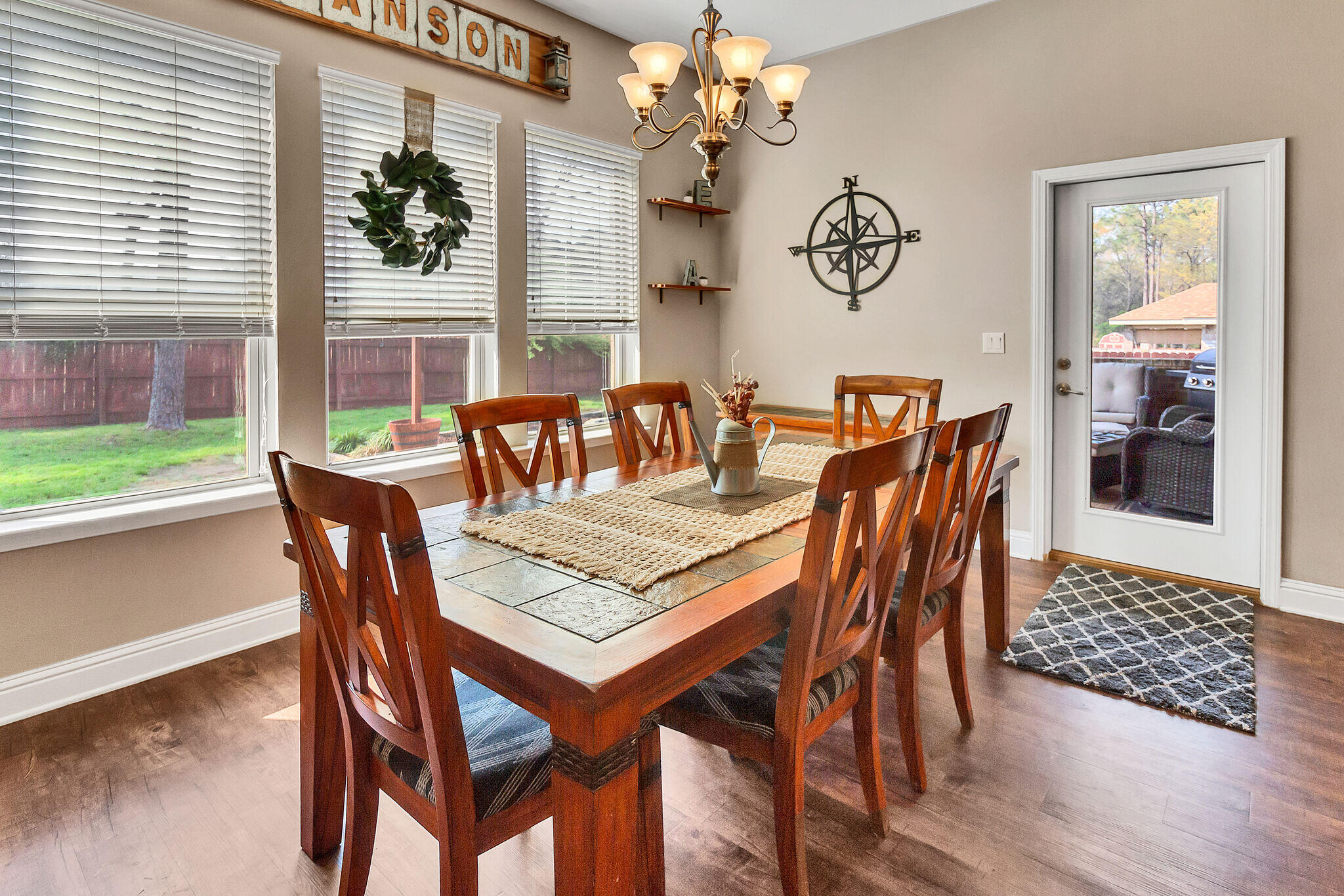 3044 Crown Creek Circle Crestview, FL 32539 - Photo 16 of 41 a dining room with furniture a large window and wooden floor