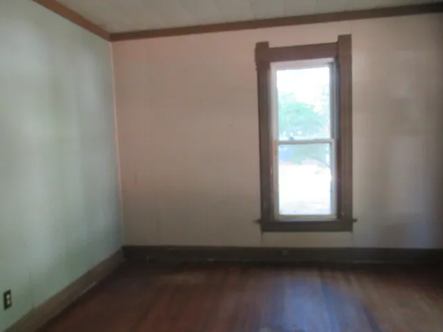 a view of a small space with wooden floor and a window