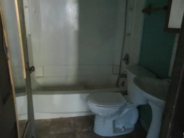 a white toilet sitting next to a shower