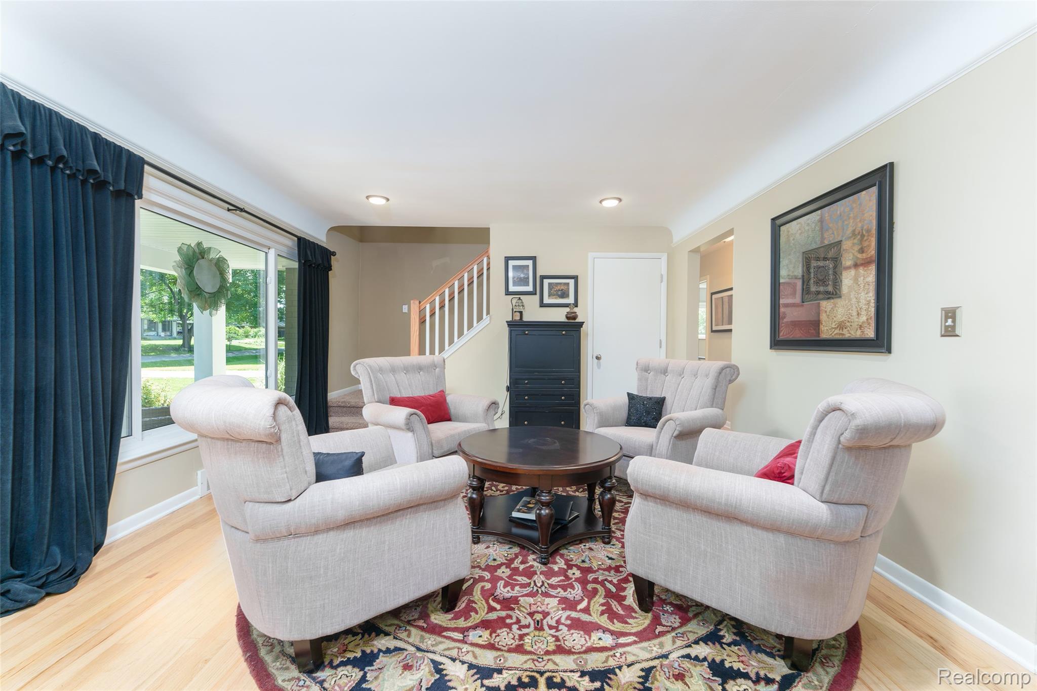 2172 Devonshire Road Bloomfield Hills, MI 48302 - Photo 8 of 45 Living area featuring light wood-finish flooring, a large window, recessed lighting, crown molding, and a staircase with white balusters