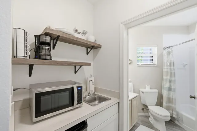 a bathroom with a sink a toilet and shower curtain