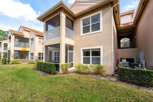 a front view of a house with a yard and potted plants
