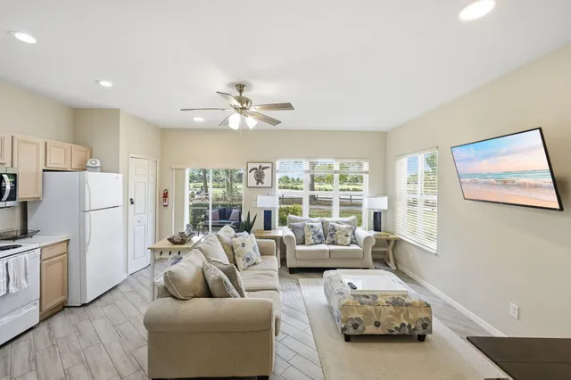 a living room with furniture kitchen view and a refrigerator