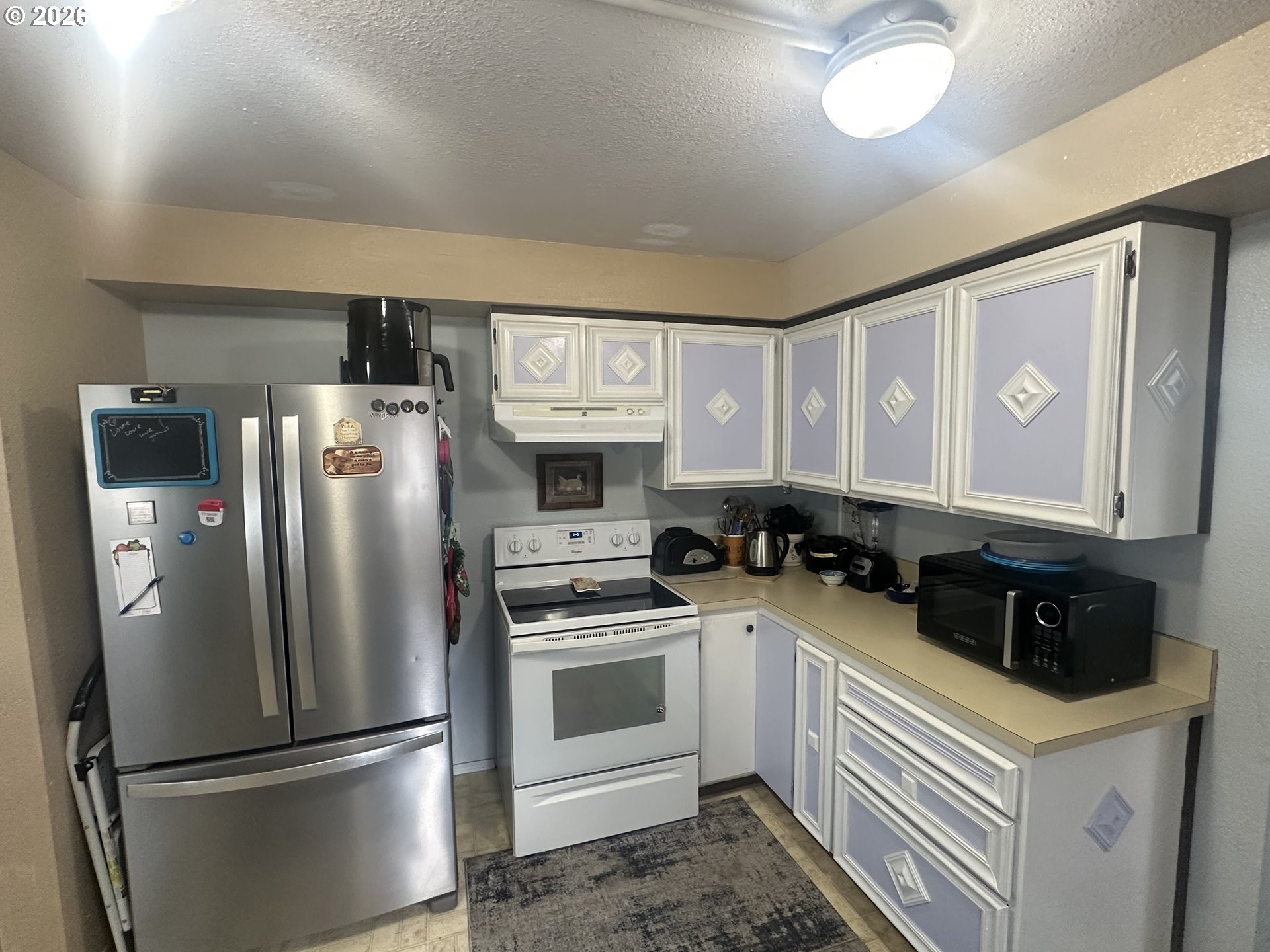 2063 Alder Avenue Reedsport, OR 97467 - Photo 9 of 29 a kitchen with stainless steel appliances a refrigerator a stove a sink and white cabinets