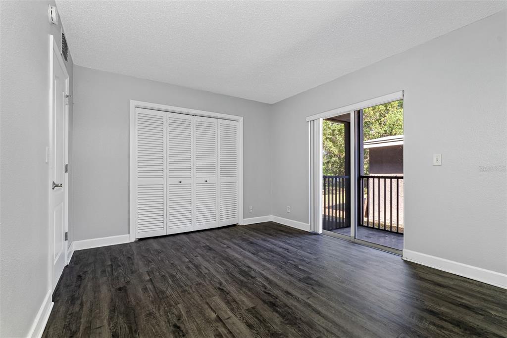 263 14th Street Northwest, Unit 3A Largo, FL 33770 - Photo 9 of 11 an empty room with wooden floor and windows