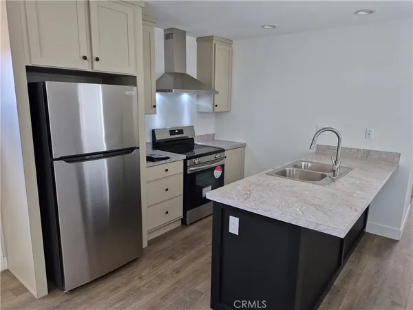 a kitchen with appliances a sink and a refrigerator